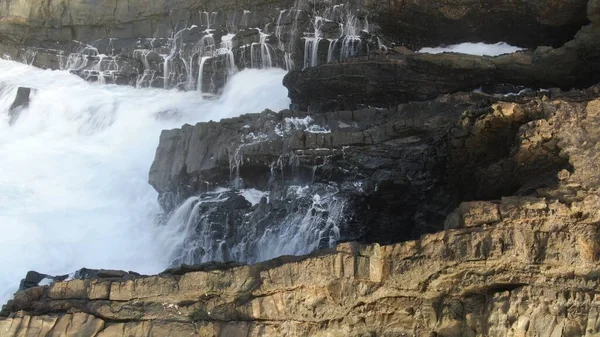 Okyanusun gücü dağların yanındaki kayalıklara çarpar.