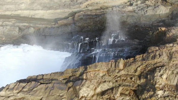 Okyanusun gücü dağların yanındaki kayalıklara çarpar.