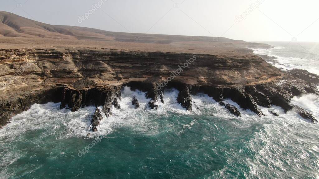 the force of the ocean hits the cliffs next to the mountains