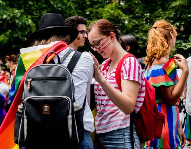 Güzel lezbiyen kızlar neşeleniyor ve arkadaşlarıyla geçit töreninin keyfini çıkarıyorlar.