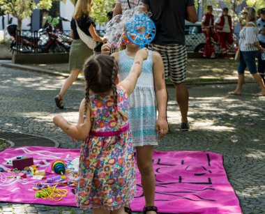 Gurur festivali sırasında baloncuklarla oynayan tatlı küçük bir kız ve ayrıca LGBTQ + topluluğunu destekliyor.