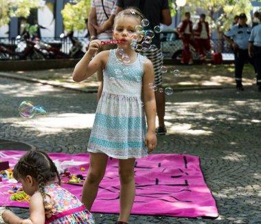 Gurur festivali sırasında baloncuklarla oynayan tatlı küçük bir kız ve ayrıca LGBTQ + topluluğunu destekliyor.