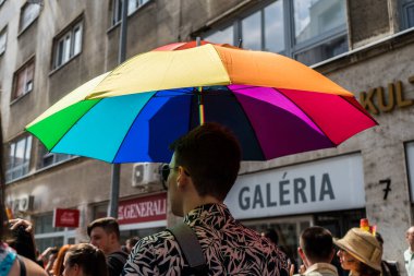 Yazın Bratislava 'daki eşcinsel yürüyüşüne katılırken elinde gökkuşağı şemsiyesi tutan eşcinsel bir adam..