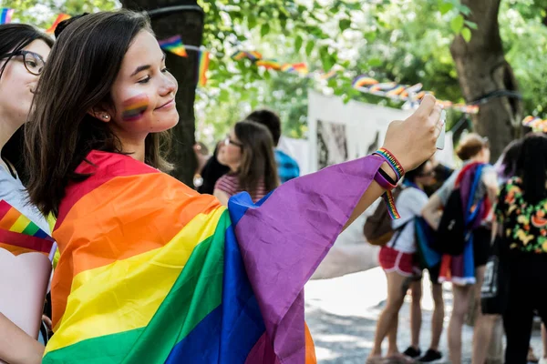 可愛いですレズビアン若いです女の子笑顔で素晴らしい虹の旗と彼女の顔に虹のメイク中にプライドパレード — ストック写真
