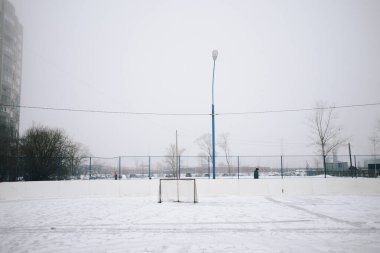 Kışın futbol sahası, soğuk bir günde gri gökyüzünün altındaki eski oyun alanı.