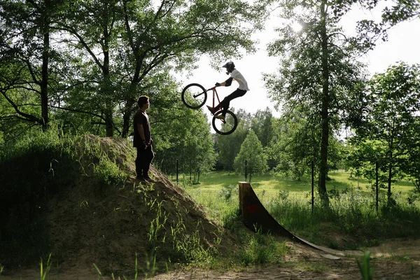 Motero haciendo trucos en el bosque, ciclista profesional en el bosque — Foto de Stock