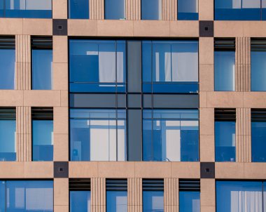 Şehir merkezinde modern mimarinin dış cephesi. Yapı özeti arka plan. Ön cephenin pencereli ayrıntıları. Basit çok katlı ofis binası, iş merkezi..