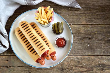 Ketçap, hardal, mayonez ve Marine salatalık ile Fransız sosisli sandviç.