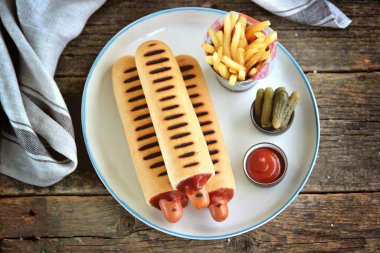 Ketçap, hardal, mayonez ve Marine salatalık ile Fransız sosisli sandviç.