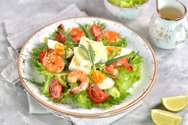 Roka, büyük karides, cherry domates, haşlanmış yumurta, brie peyniri ve rendelenmiş parmesan peyniri ile sağlıklı marul salatası.