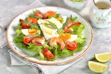 Roka, büyük karides, cherry domates, haşlanmış yumurta, brie peyniri ve rendelenmiş parmesan peyniri ile sağlıklı marul salatası.