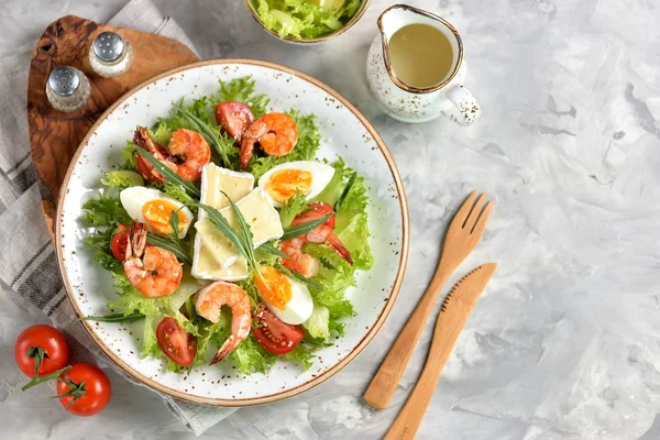 Roka, büyük karides, cherry domates, haşlanmış yumurta, brie peyniri ve rendelenmiş parmesan peyniri ile sağlıklı marul salatası.