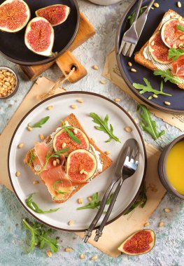 Çavdar ekmeği yumuşak peynir, jamon, incir, roka ve çamfıstıklı sağlıklı sandviç.