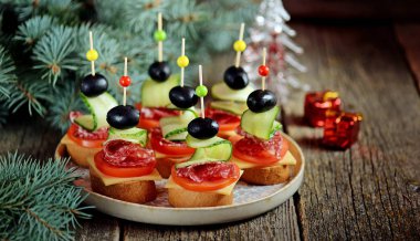 Canap şiş ekmeği baget ekmek peynir, sosis, domates, salatalık ve zeytin ile gelen üzerinde. Yeni yıl için geleneksel snack.