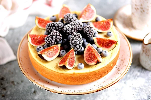 Homemade delicious cheesecake with fresh figs and frozen blueberries and blackberries. Healthy baking in multicooker