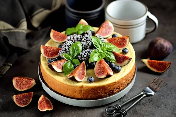 Homemade delicious cheesecake with fresh figs and frozen blueberries and blackberries. Healthy baking in multicooker