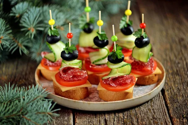 トーストのチーズ ソーセージ トマト キュウリとオリーブとパンのバゲットから串のカナッペ 新しい年の伝統的なスナック — ストック写真