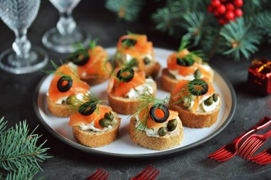 Krem peynir, tuzlanmış somon, kapari, zeytin ve dereotu ile kanepeler. Üstten görünüm. 