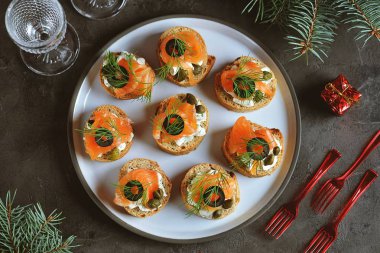 Krem peynir, tuzlanmış somon, kapari, zeytin ve dereotu ile kanepeler. Üstten görünüm. 