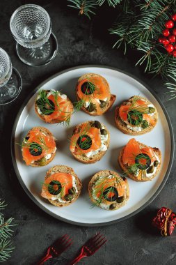 Krem peynir, tuzlanmış somon, kapari, zeytin ve dereotu ile kanepeler. Üstten görünüm. 