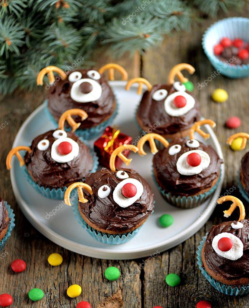 Homemade funny cupcakes Santa's reindeers on a wooden background. Christmas idea for kids.