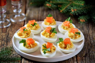 Peyniri, kapari ve tuzlanmış somon ile doldurulmuş tavuk yumurtası. Noel arka plan.
