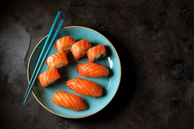 Philadelphia Ev yapımı suşi mavi bir tabak içinde bir siyah arka plan üzerine alır. Üstten görünüm. Kopya alanı. 