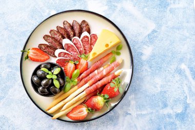 Antipasti aperatifler - sosis, jamon, zeytin, çilek, Kapari, cherry domates, beyaz şarap, ev yapımı grisini kurutulmuş domates ve daha fazlası. Üstten Görünüm. 