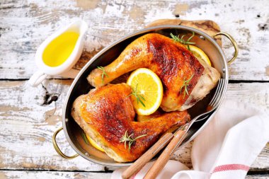 Portakal dilim ve biberiye ile pişmiş tavuk budu.