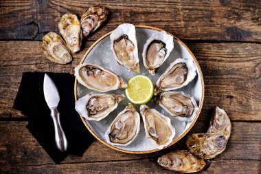 Eski ahşap zemin üzerine buz limon dilimleri ile taze okyanus istiridye. Üstten Görünüm. 