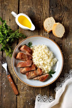 Eski ahşap zemin üzerine haşlanmış pirinç ile ızgara domuz.