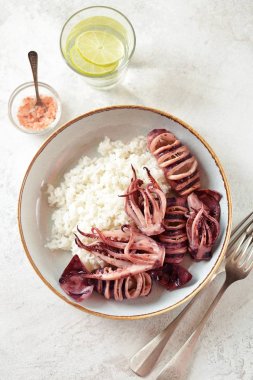 Hafif bir arka plan üzerinde haşlanmış pirinç ile ızgara bütün kalamar. Sağlıklı Asya gıda.