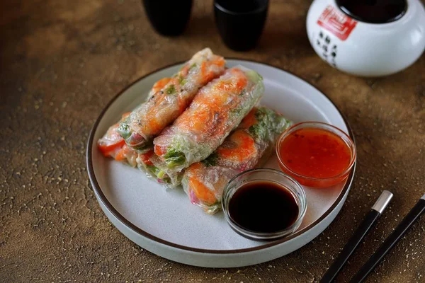 Rice spring rolls - rice paper, carrots, watermelon radish, tomato, cucumber, coriander and fried shrimp. Healthy food.
