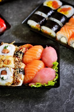 Somon, yumuşak peynir, ton balığı, füme eel ile suşi seti. Eve suşi teslimatı. Sağlıklı yiyecekler. Üstte görüntü. 