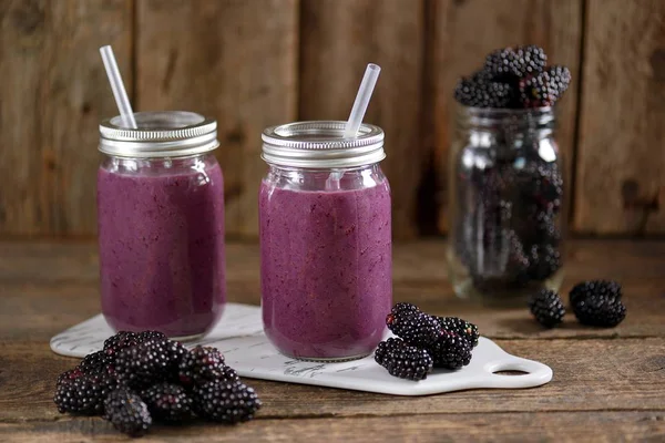 健康的黑莓有机冰沙与天然酸奶和蜂蜜在一个玻璃罐在一个古老的木制背景 — 图库照片