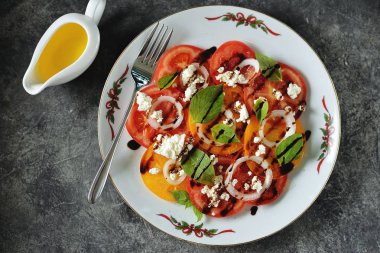 Fesleğen, yumuşak peynir, soğan, zeytinyağı ve balzamik krema ile sarı ve pembe domates Salatası.