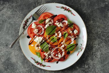 Fesleğen, yumuşak peynir, soğan, zeytinyağı ve balzamik krema ile sarı ve pembe domates Salatası.