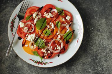 Fesleğen, yumuşak peynir, soğan, zeytinyağı ve balzamik krema ile sarı ve pembe domates Salatası.