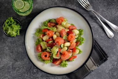 Kiraz domates, salatalık, biber, biraz tuzlu somon, zeytinyağı ve marul ile sağlıklı patates gnocchi salata. Üstte görüntü. 