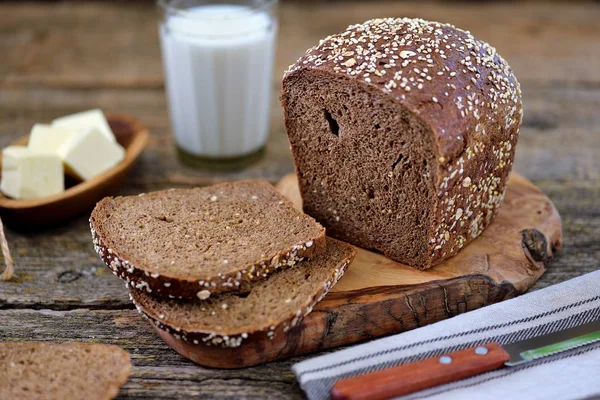 Healthy rye bread with organic milk and butter on an old wooden background.