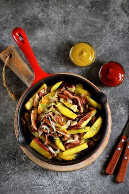 Füme domuz kulaklı kızarmış patates, soğan ve dökme demir tavada dereotu..