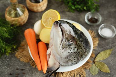 Balık çorbası için malzemeler - somon başı, patates, havuç, soğan, limon, defne yaprağı, dereotu ve maydanoz..