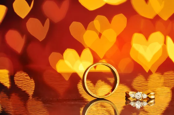 Two golden wedding rings with heart bokeh on background.Concept of love, Valentine, soul mate, destiny.