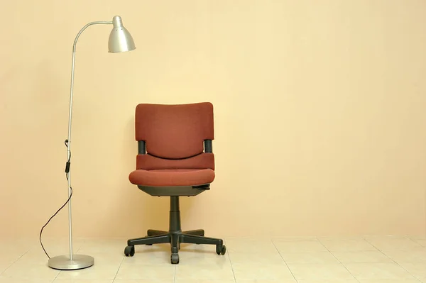 Roter Bürostuhl Mit Lampe Über Hellbeigem Wandhintergrund — Stockfoto