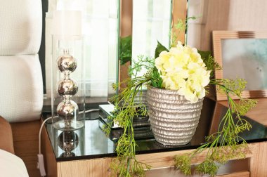 Yapay buket çiçek metal kavanoza başucundaki dekore edilmiştir..