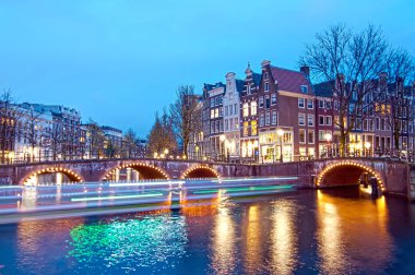 Alacakaranlık süre boyunca, Hollanda Keizersgracht Kavşağı köprü görünümü Amsterdam kanal ve tarihi evler.