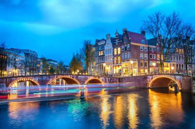 Alacakaranlık süre boyunca, Hollanda Keizersgracht inersection köprü görünümü Amsterdam kanal ve tarihi evler.