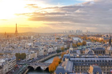 Paris manzarası ile Notre Dame Katedrali tepesinden görülen renkli günbatımı ışık görünümünü.