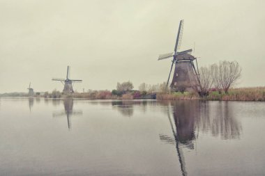 Ünlü Hollanda ahşap yel, Unesco Dünya Mirası, vintage tarzı ile kış günbatımı yumuşak ışığında doğal fırıldak Köyü.