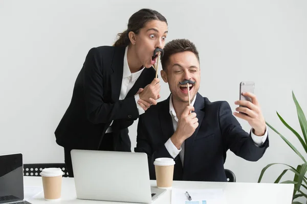 Colegas fazendo auto-retrato com acessório bigode — Fotografia de Stock